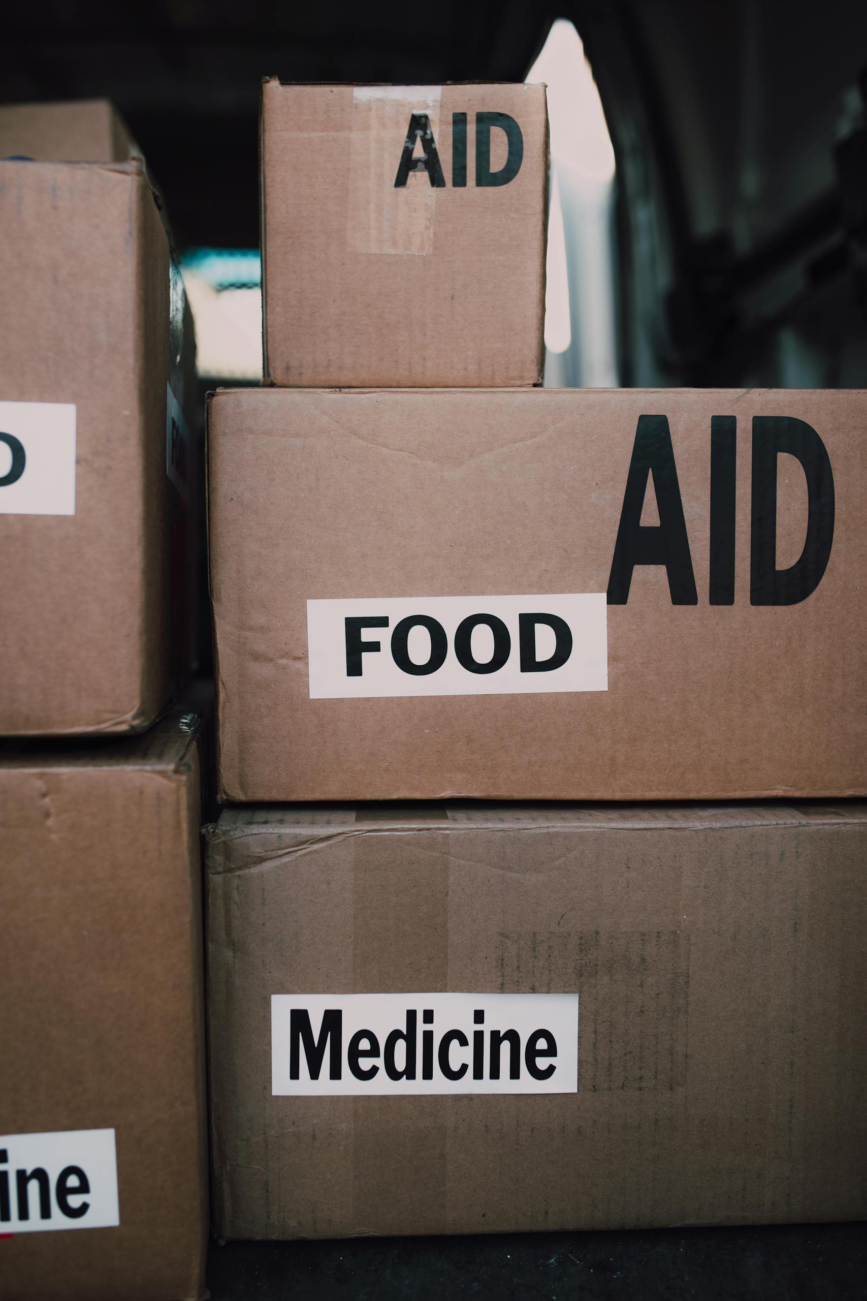 Close-up of aid packages with labels for food and medicine, symbolizing charity and support.