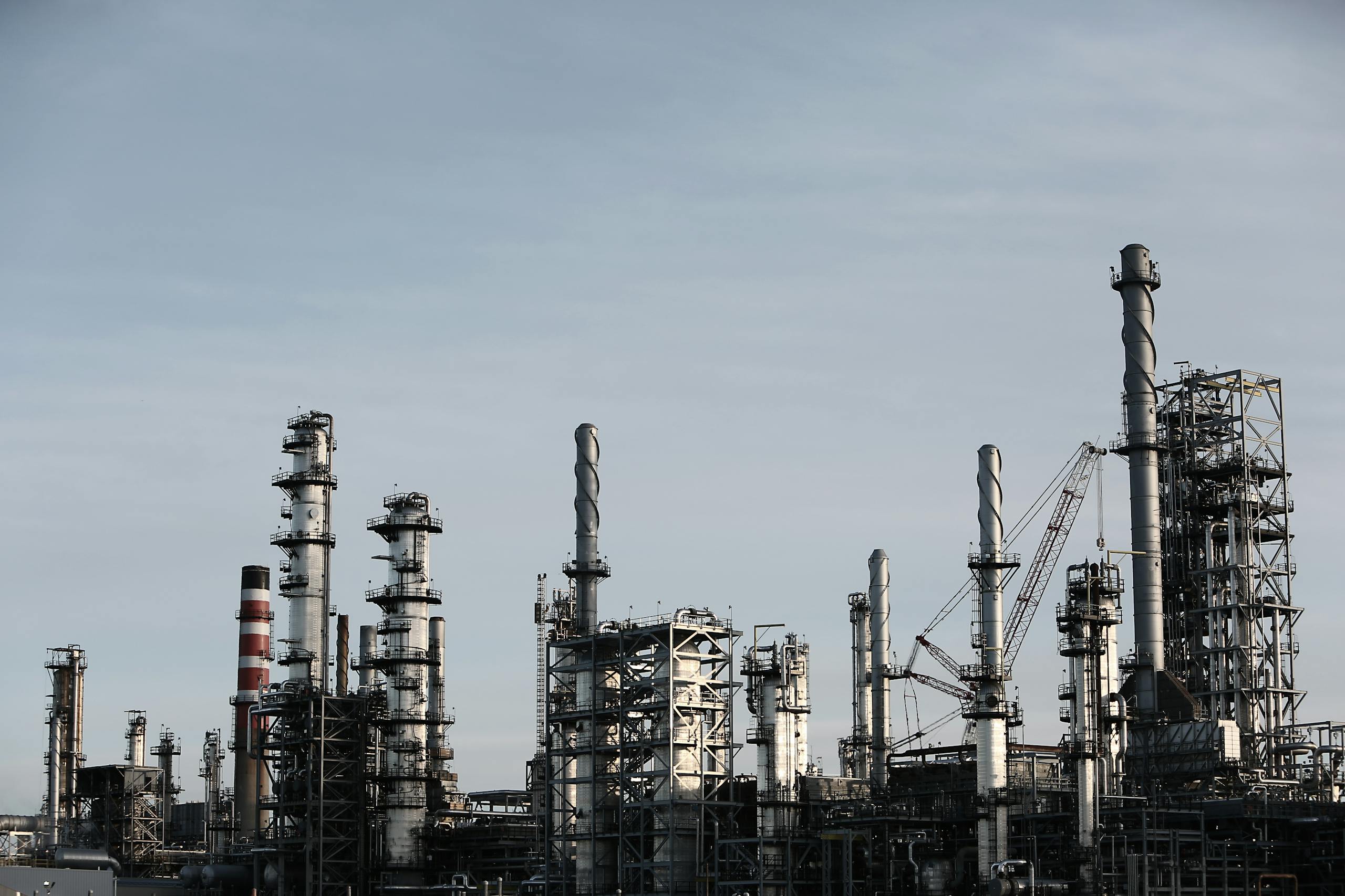 Skyline view of an industrial factory with tall chimneys against a clear sky.