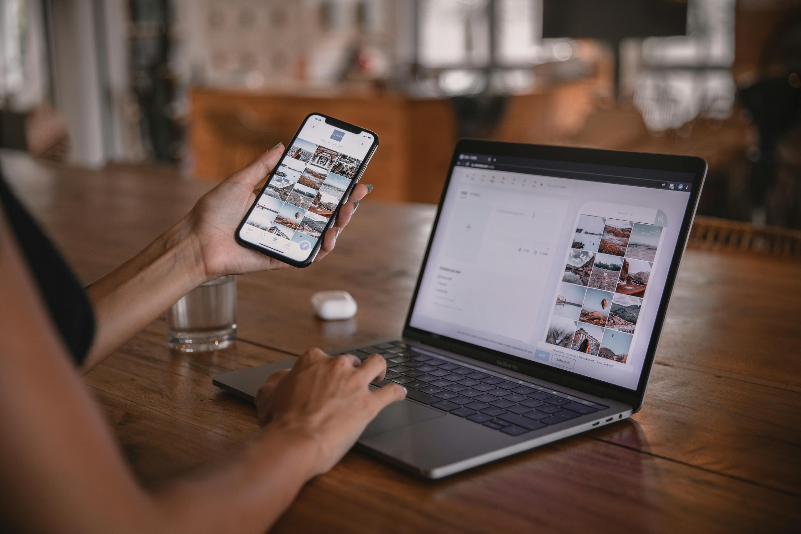 Woman edits social media content on phone and laptop at a cafe in Bali.